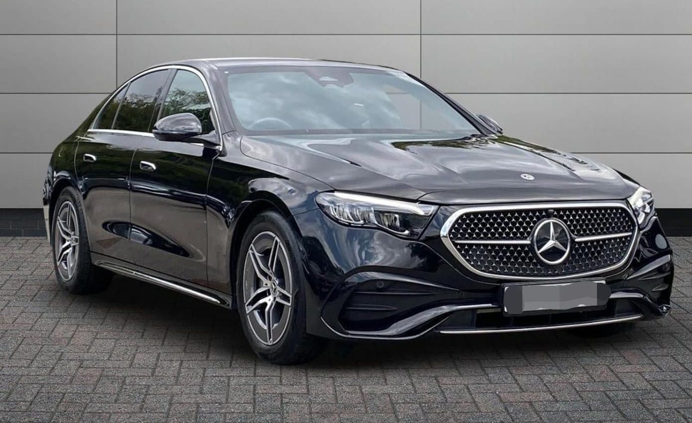Black Mercedes-Benz E-Class saloon parked on a brick-paved forecourt